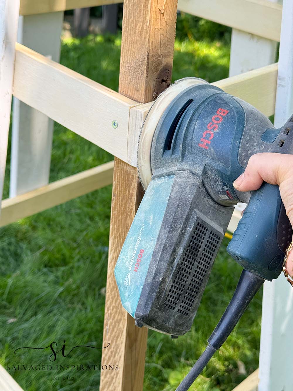 Sanding Scrap Wood Boards on Obelisk Trellis